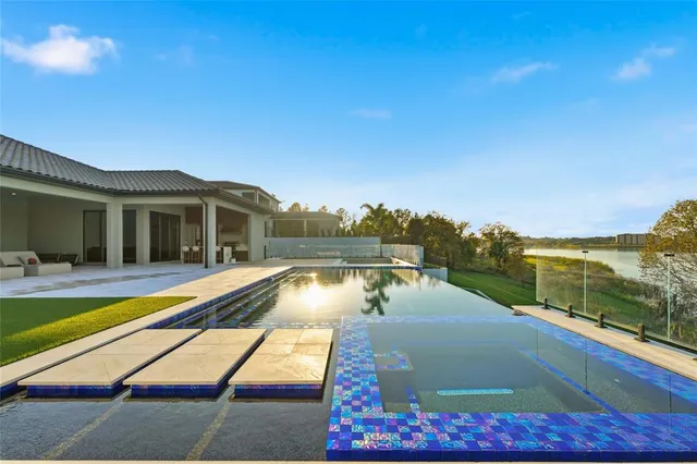 a view of a house with pool and sitting area