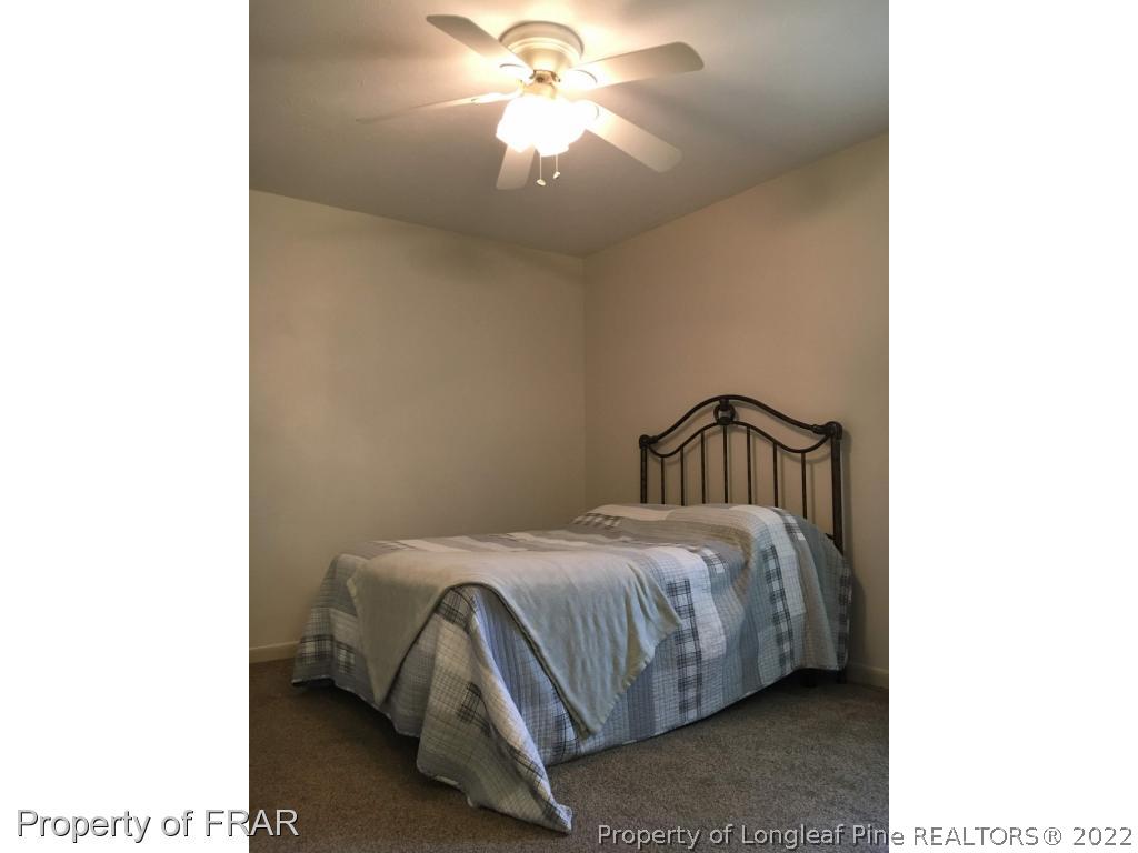 1733 Rim Road Fayetteville, NC 28314 - Photo 11 of 23 a bedroom with a bed and a chandelier
