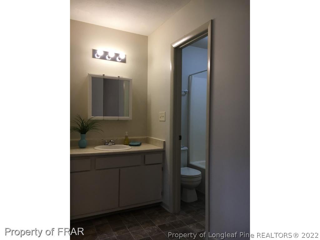 1733 Rim Road Fayetteville, NC 28314 - Photo 13 of 23 a bathroom with a toilet sink and mirror