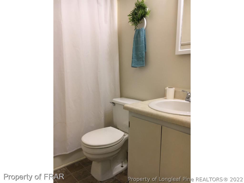 1733 Rim Road Fayetteville, NC 28314 - Photo 15 of 23 a bathroom with a sink a toilet and a mirror