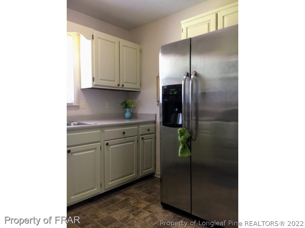 1733 Rim Road Fayetteville, NC 28314 - Photo 7 of 23 a kitchen with a refrigerator and cabinets