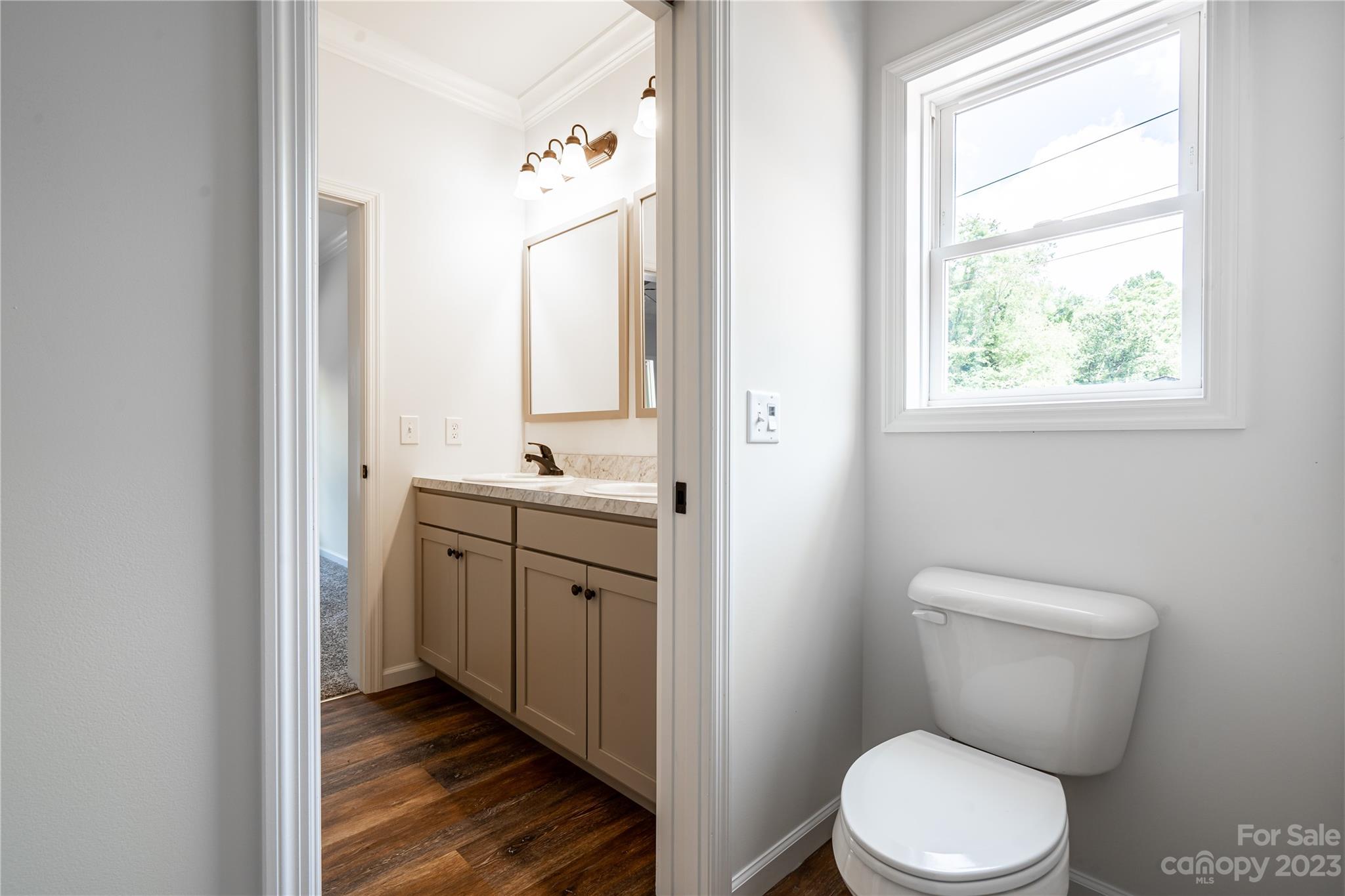 85 Rocky Lane Road Clyde, NC 28721 - Photo 20 of 37 a bathroom with a toilet a sink a mirror a window and vanity