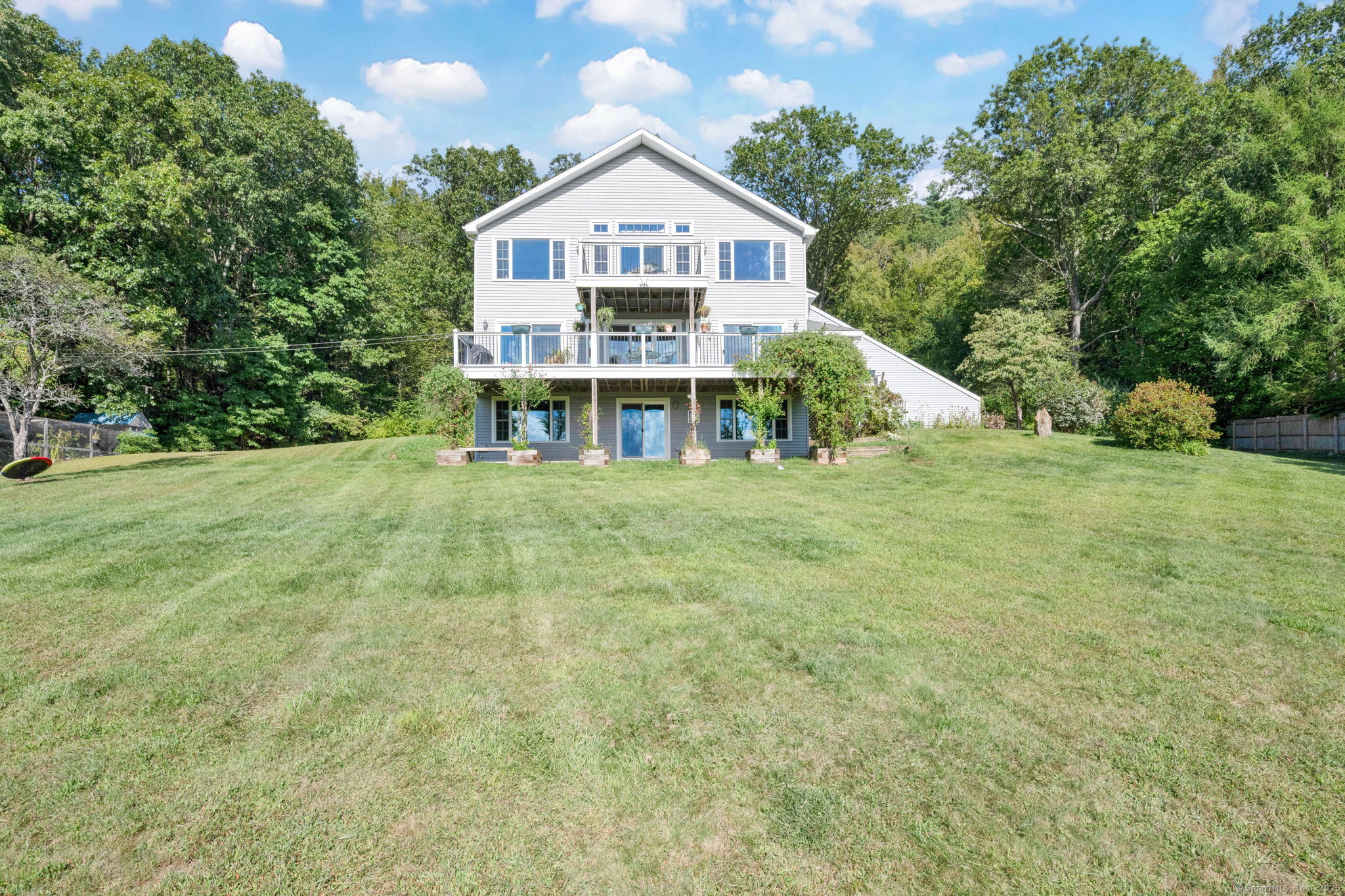 a view of a house with a big yard and large trees