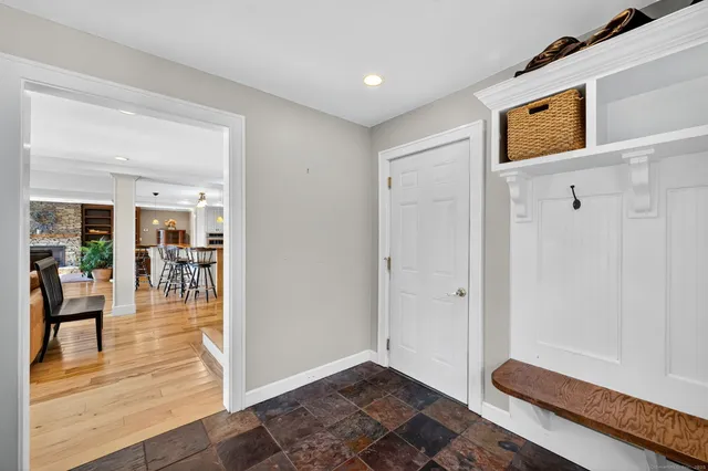 a view of a hallway with wooden floor and windows