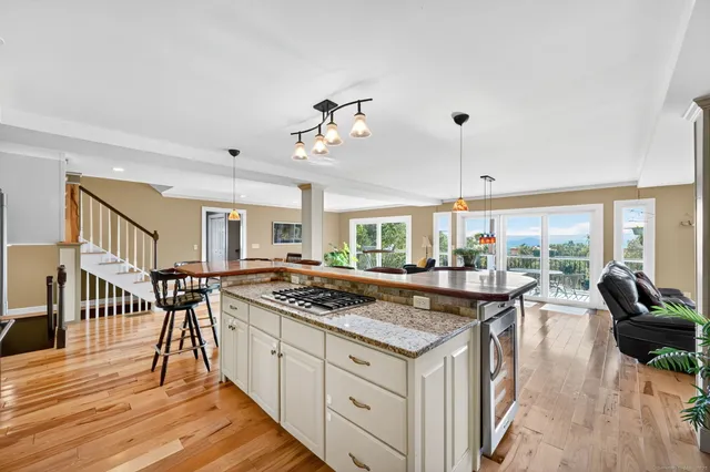 a kitchen with a stove a refrigerator a dining table and chairs with wooden floor