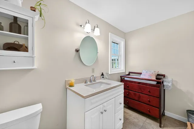 a bathroom with a toilet a sink and a mirror