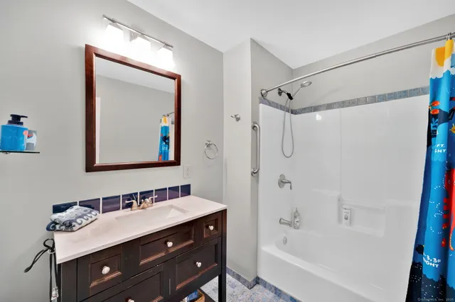 a bathroom with a tub sink double vanity and a mirror