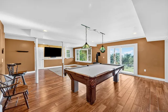 a living room with furniture a flat screen tv and wooden floor
