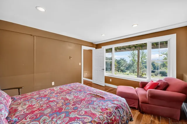 a bedroom with a bed and a large window