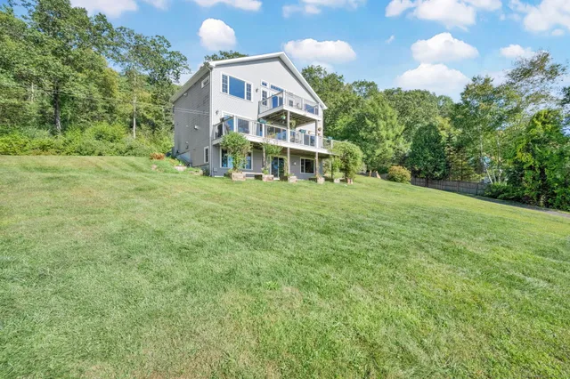 a front view of a house with a yard and trees