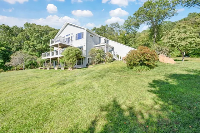 a front view of house with yard and trees in the background