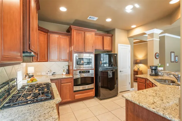 a kitchen with stainless steel appliances granite countertop a sink stove and refrigerator