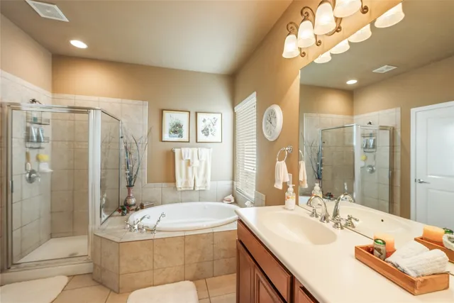 a spacious bathroom with a tub sink shower and mirror