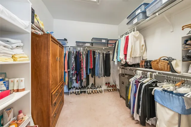 a view of walk in closet with clothes and shoes