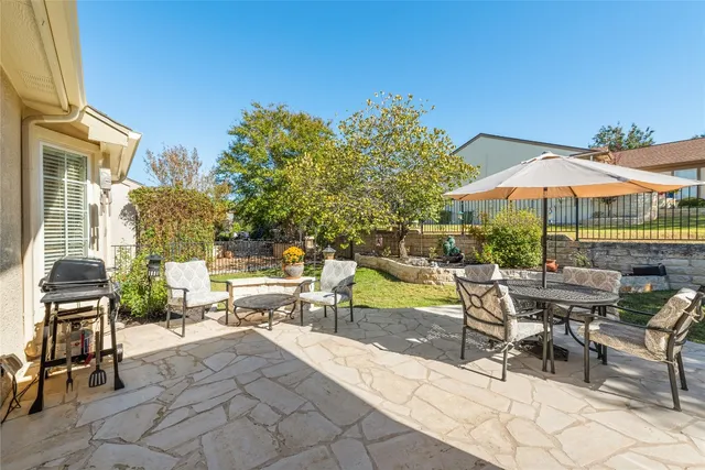 a view of a patio with a table and chairs under an umbrella