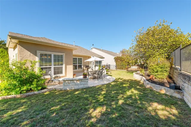 a patio with table and chairs and potted plants
