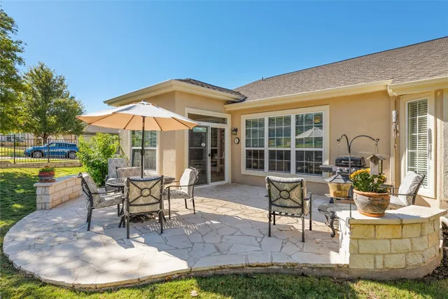 a view of a house with backyard sitting area and garden