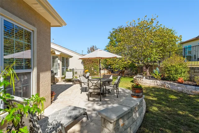 a view of a patio with table and chairs under an umbrella