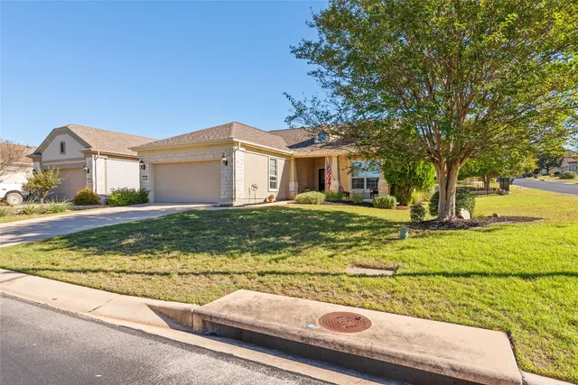 a view of a house with a big yard and large trees
