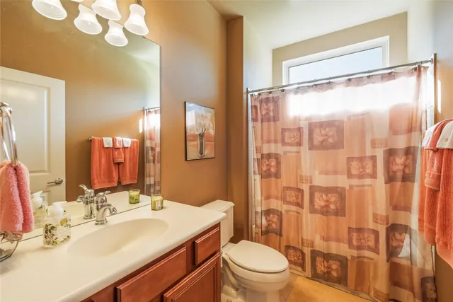 a bathroom with a sink vanity mirror and toilet