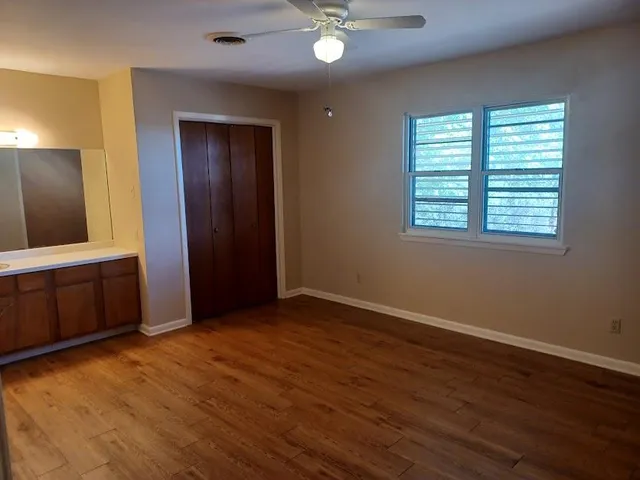 an empty room with wooden floor and windows