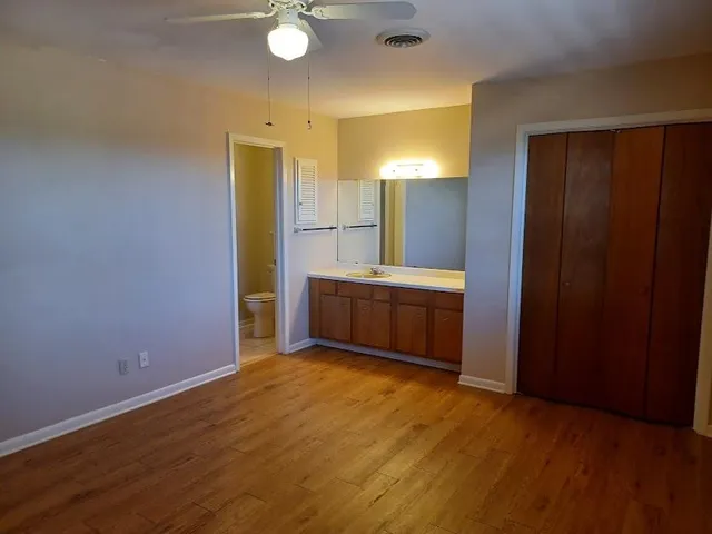 a view of an empty room with window and bathroom