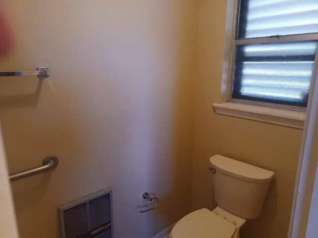 a white toilet sitting next to a shower