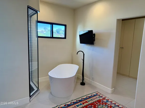 a bedroom with a bed a couch and a flat screen tv