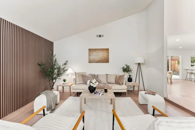 a living room with furniture a table and wooden floor