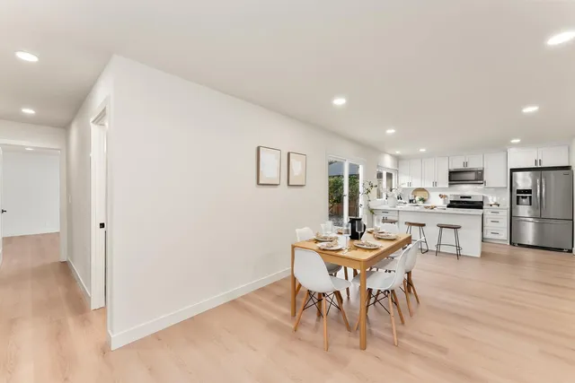 a dining room with furniture and kitchen view