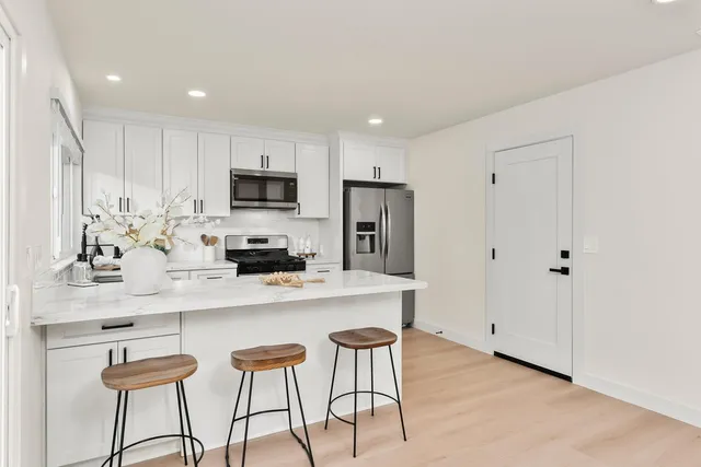 a kitchen with stainless steel appliances a refrigerator and a stove top oven