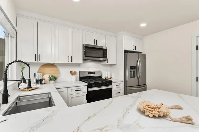 a kitchen with stainless steel appliances kitchen island granite countertop a stove and a sink