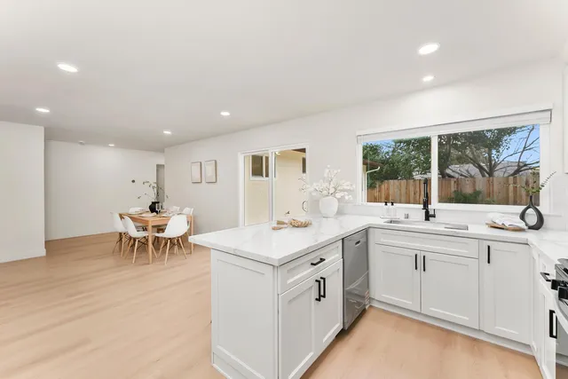 a kitchen with a sink and chairs