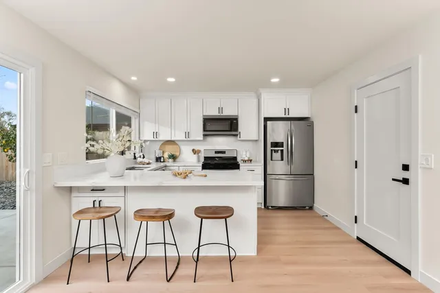 a kitchen with stainless steel appliances granite countertop a refrigerator and a stove top oven