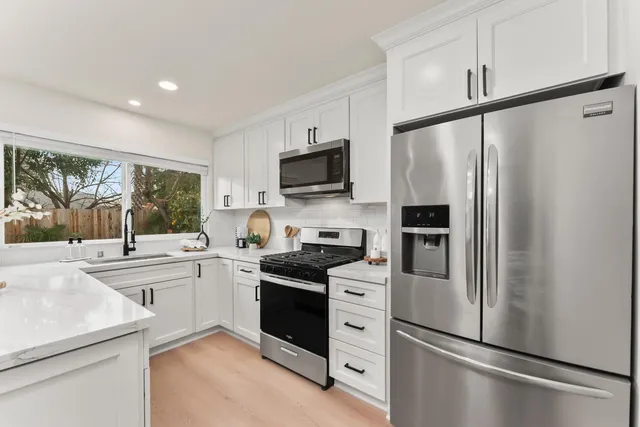 a kitchen with stainless steel appliances a refrigerator sink and microwave