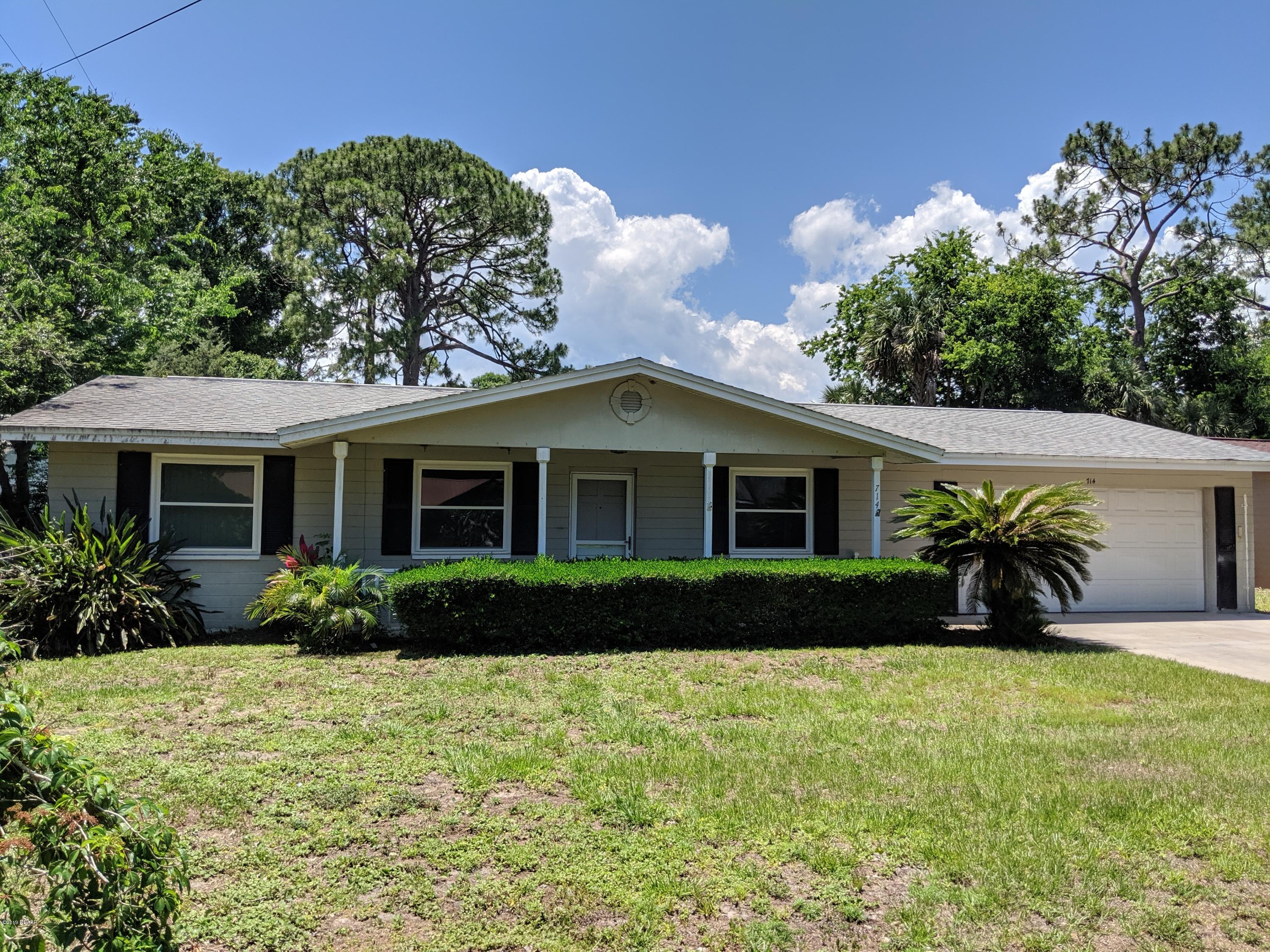 a front view of house with yard and green space