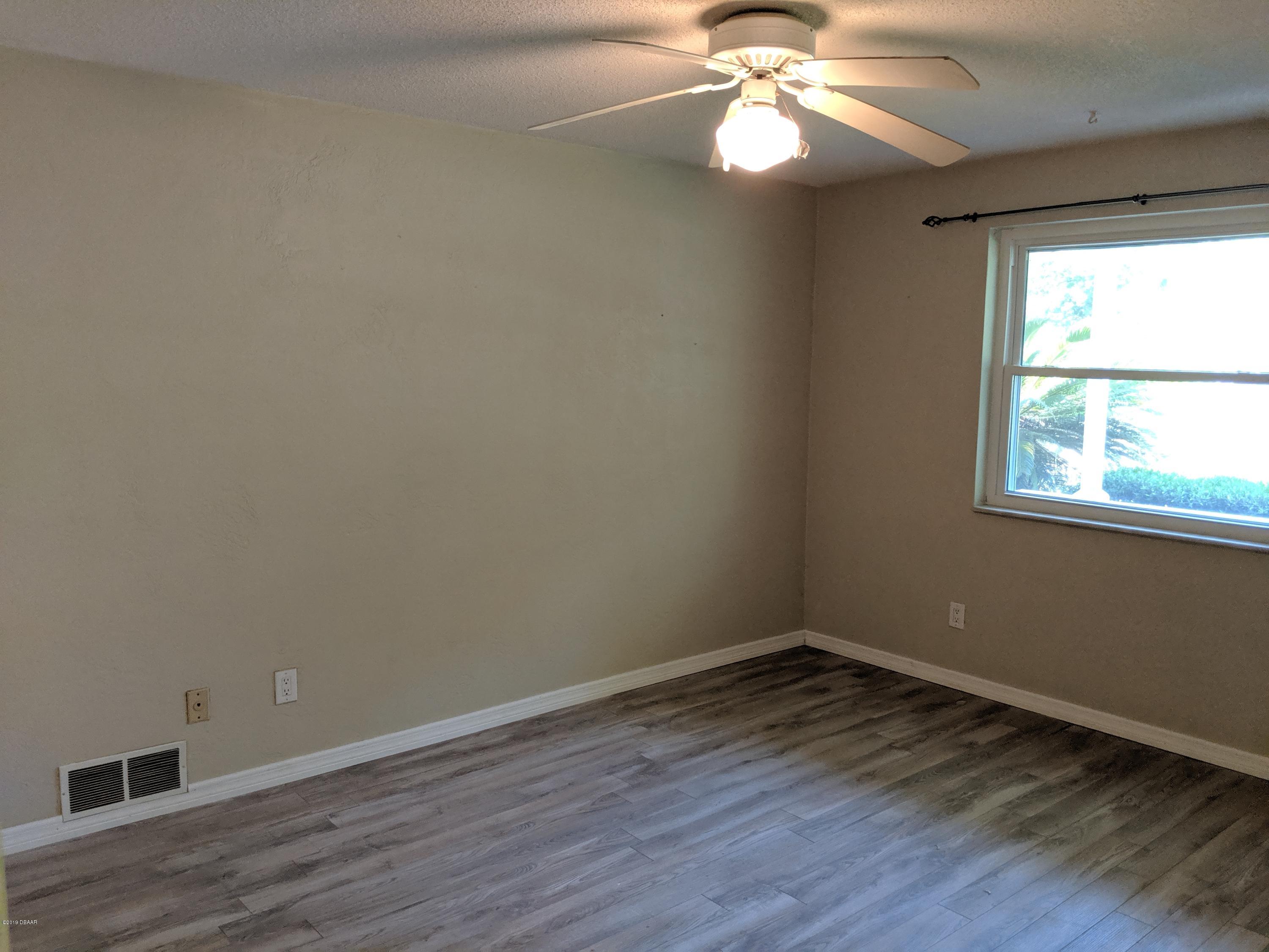 714 South Center Street Ormond Beach, FL 32174 - Photo 11 of 25 a view of an empty room with wooden floor and a window