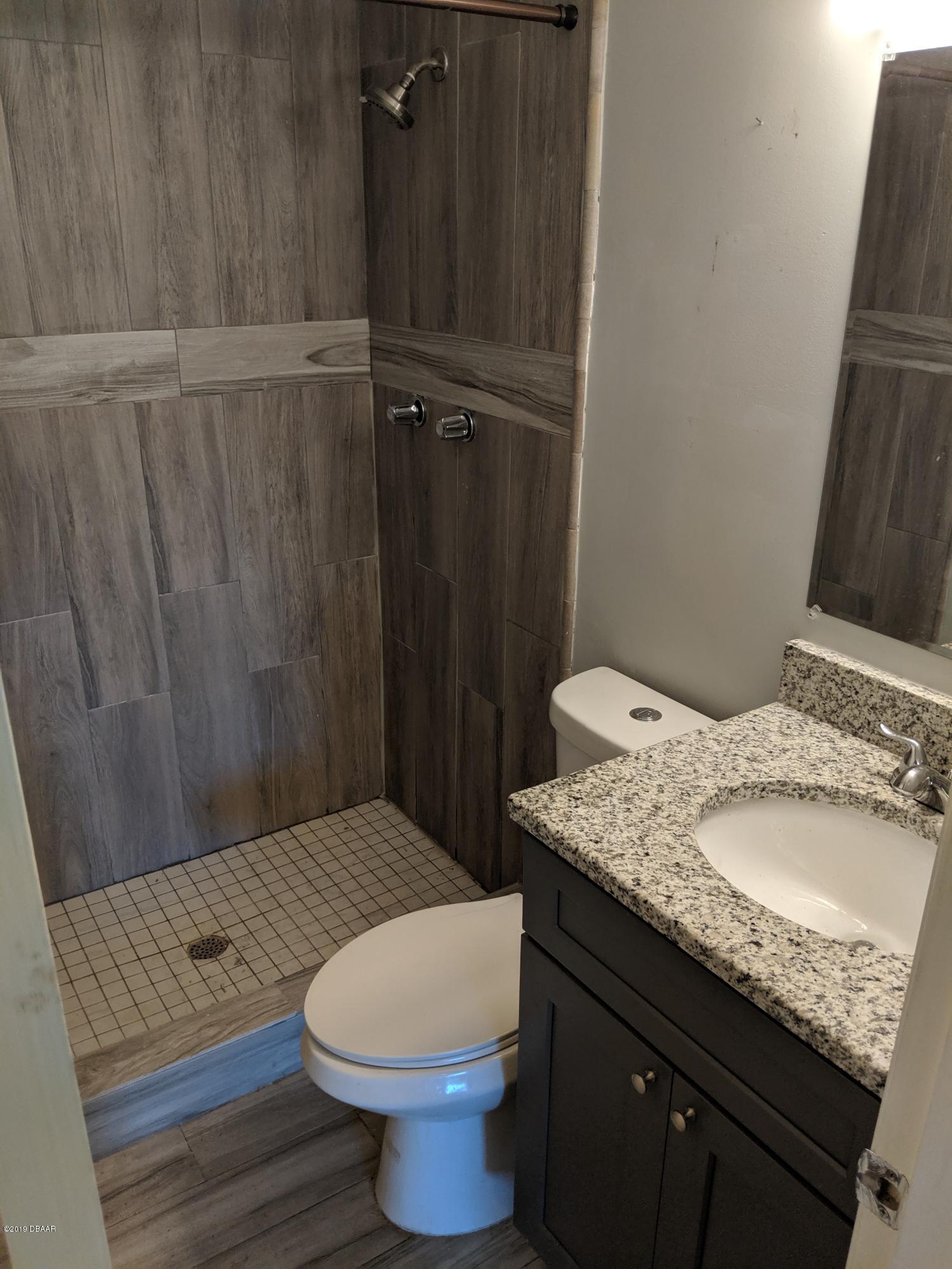 714 South Center Street Ormond Beach, FL 32174 - Photo 13 of 25 a bathroom with a granite countertop sink toilet and shower