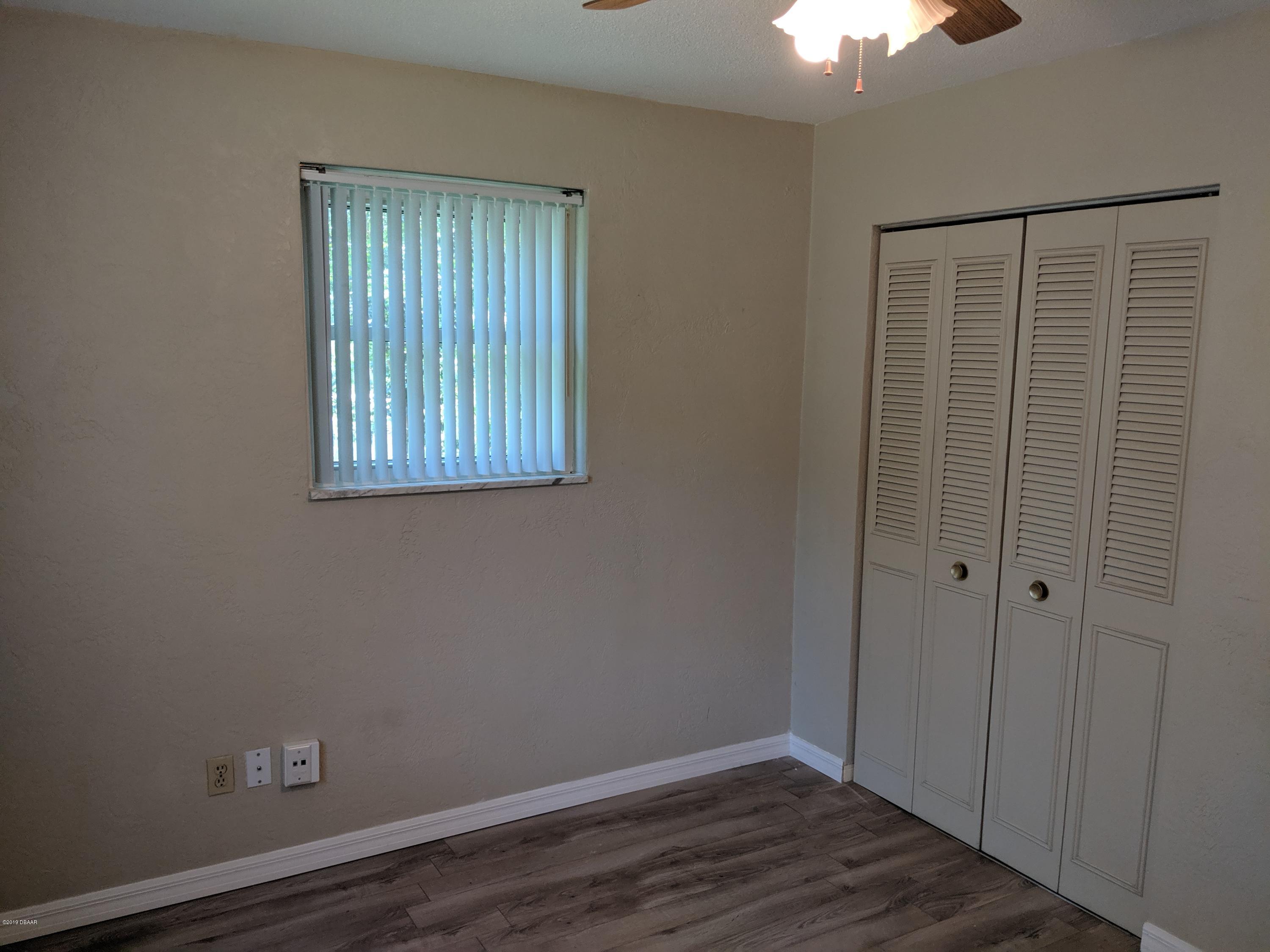 714 South Center Street Ormond Beach, FL 32174 - Photo 18 of 25 a view of an empty room with wooden floor and a window