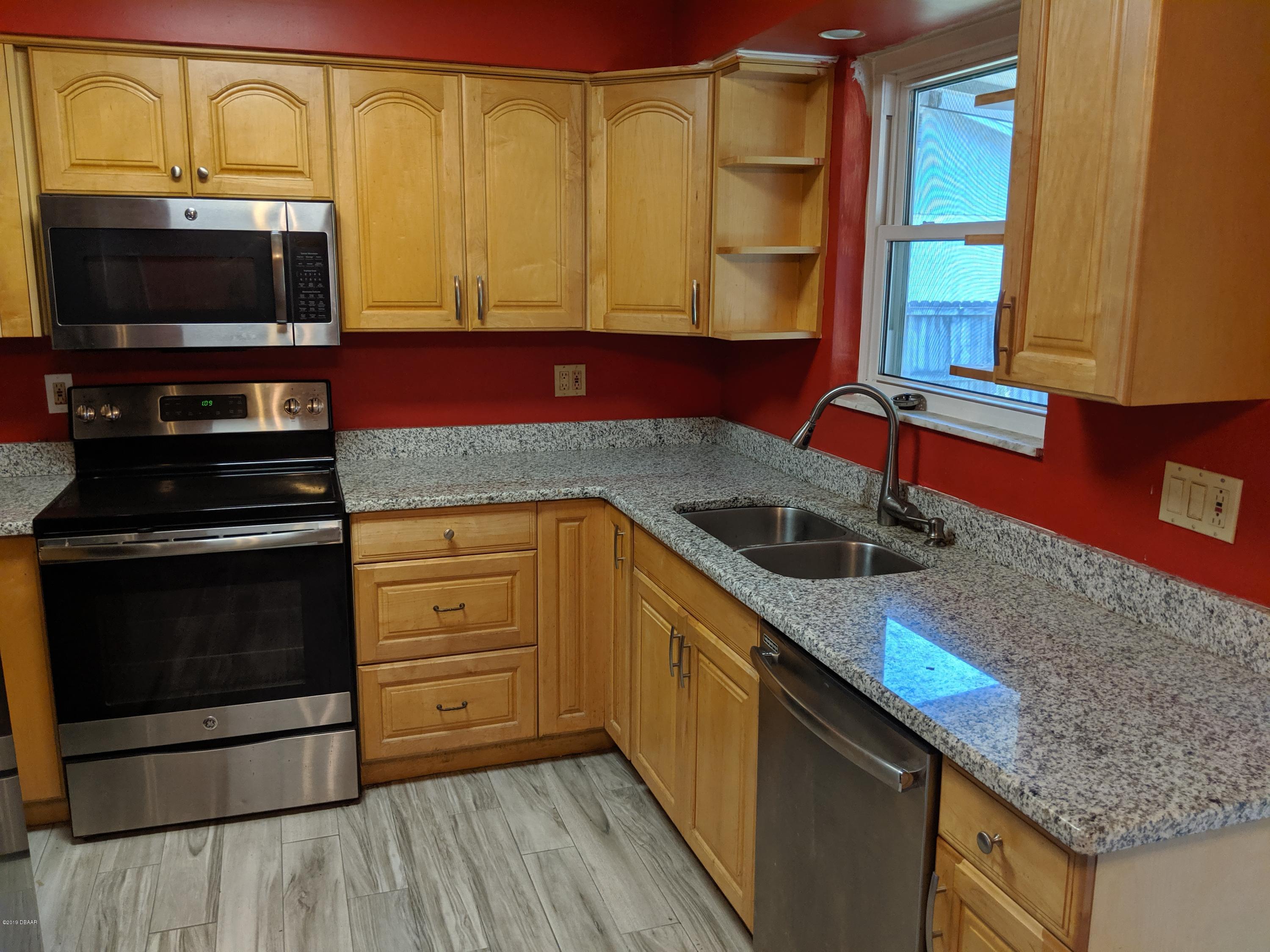 714 South Center Street Ormond Beach, FL 32174 - Photo 8 of 25 a kitchen with stainless steel appliances granite countertop a sink and a microwave