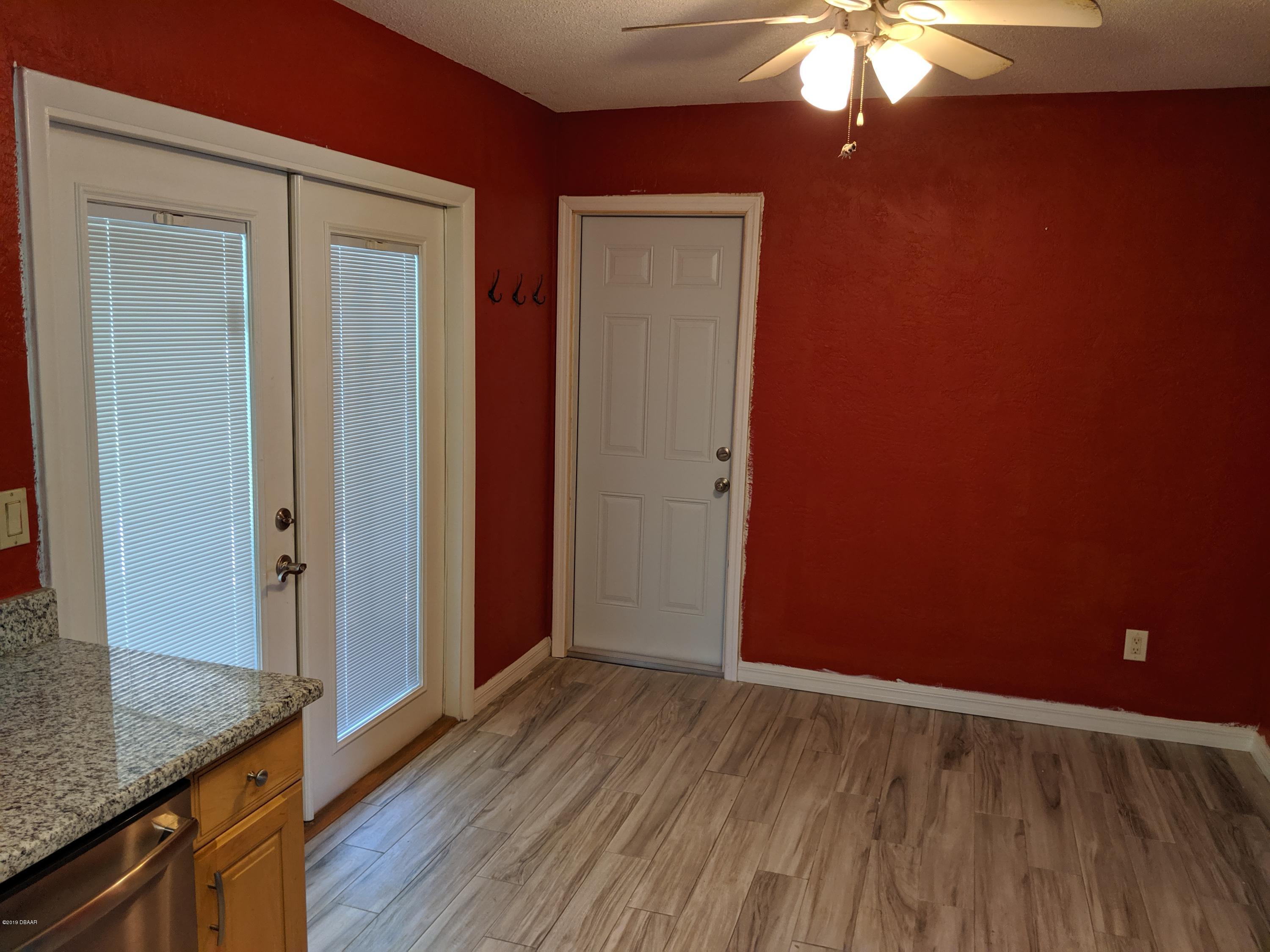714 South Center Street Ormond Beach, FL 32174 - Photo 10 of 25 an empty room with wooden floor and chandelier fan