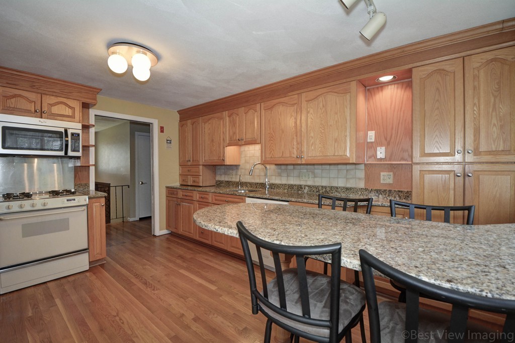 2 Linwood Road Framingham, MA 01702 - Photo 3 of 28 a kitchen with granite countertop a stove a sink and a refrigerator