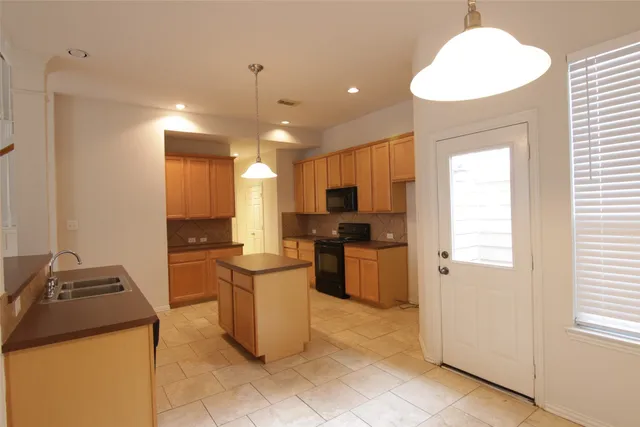 a kitchen with refrigerator and cabinets