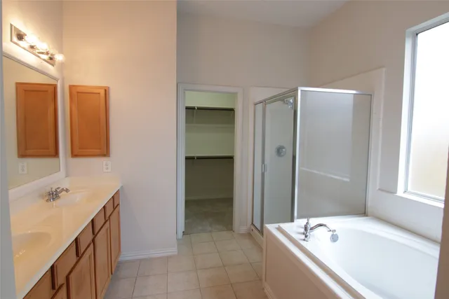 a bathroom with a tub sink and mirror