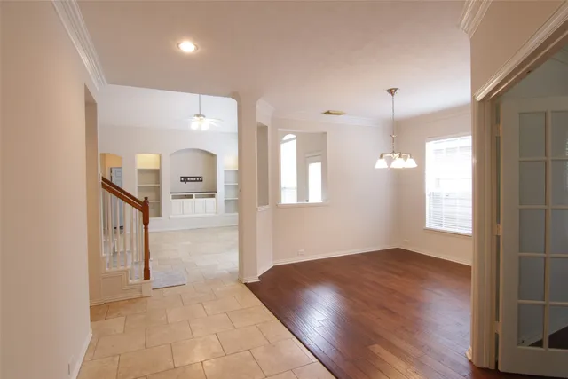a view of a hallway with wooden floor and a kitchen