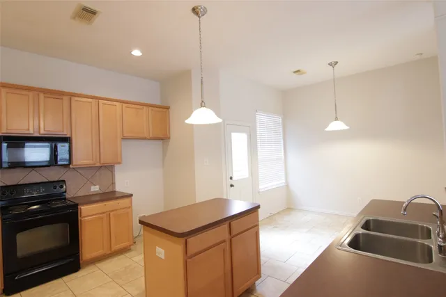 a kitchen that has a sink a stove and a microwave oven in it