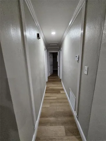 a view of a hallway with wooden floor