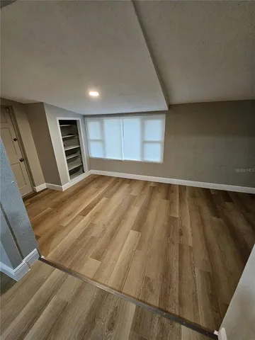 a view of an empty room with wooden floor