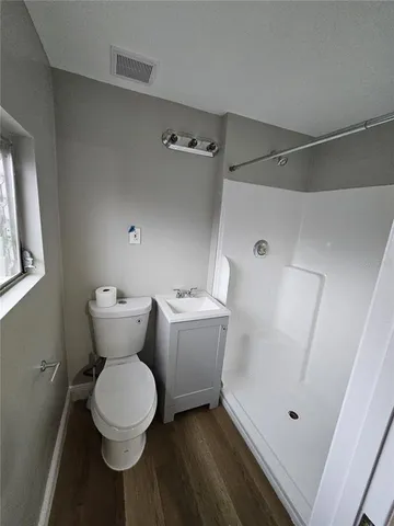 a bathroom with a toilet and a shower