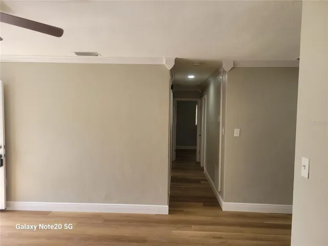 a view of a hallway with wooden floor